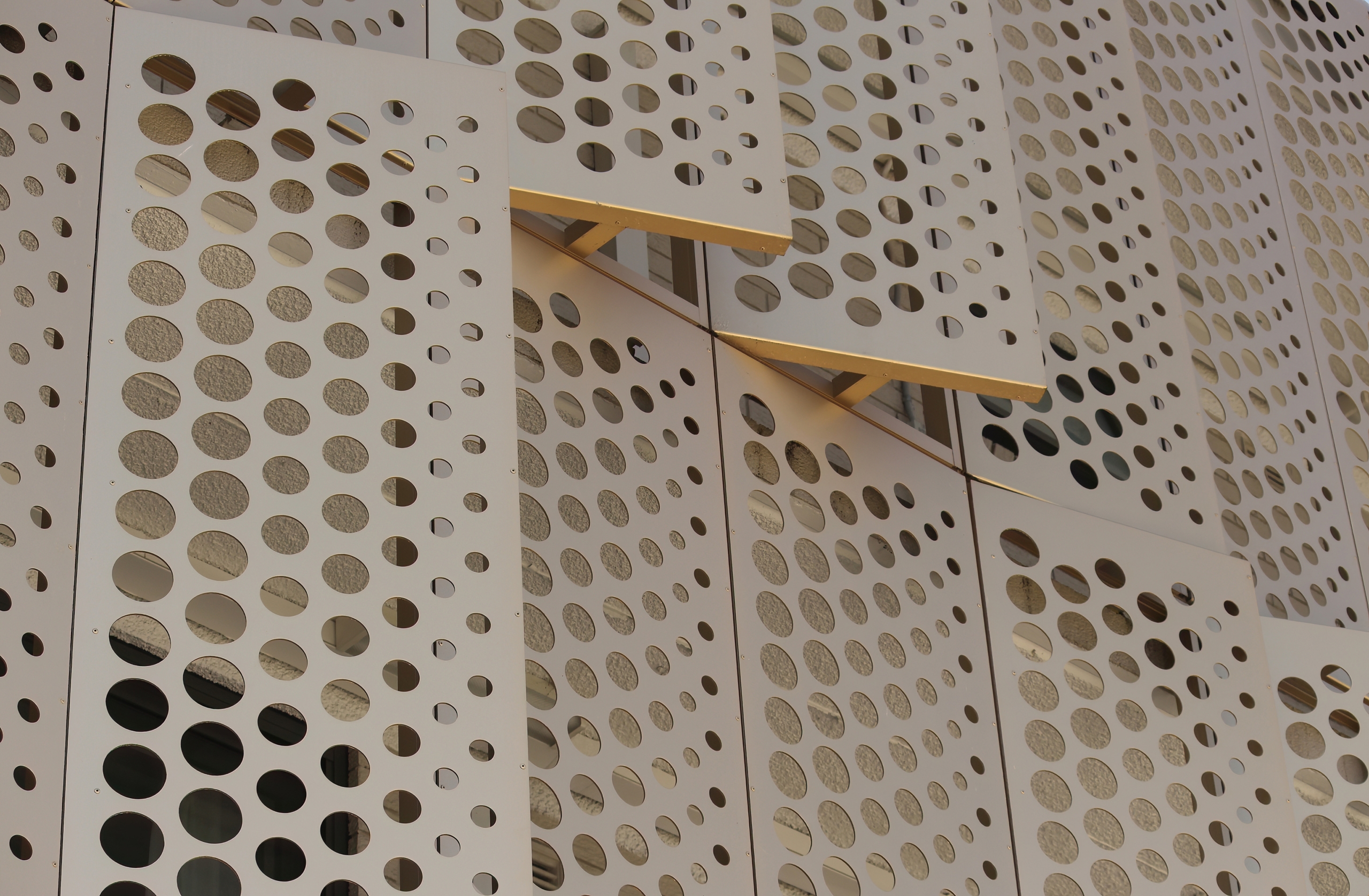 Gold,Perforated,Cladding,On,The,Outside,Of,A,Building